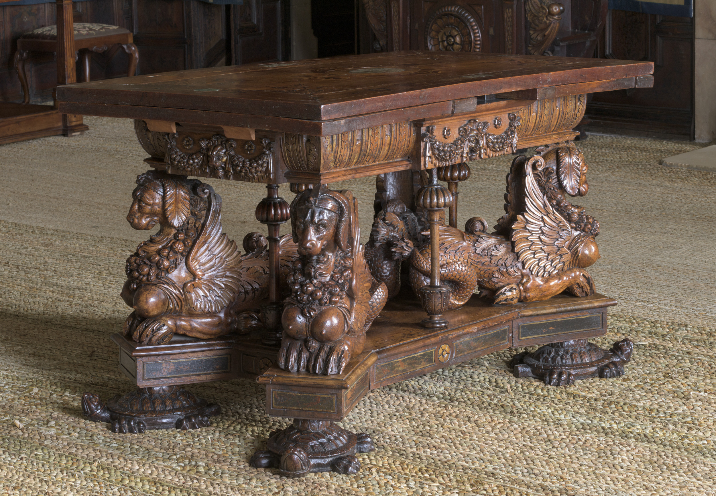 Sea Dog Table in the Withdrawing Chamber at Hardwick Hall, Derbyshire. The table is walnut, inlaid with other woods, and marble dating from around 1580. The legs are in the form of chimeras, or sea dogs, resting on tortoises. It is one of the most important surviving pieces of sixteenth century furniture in England.