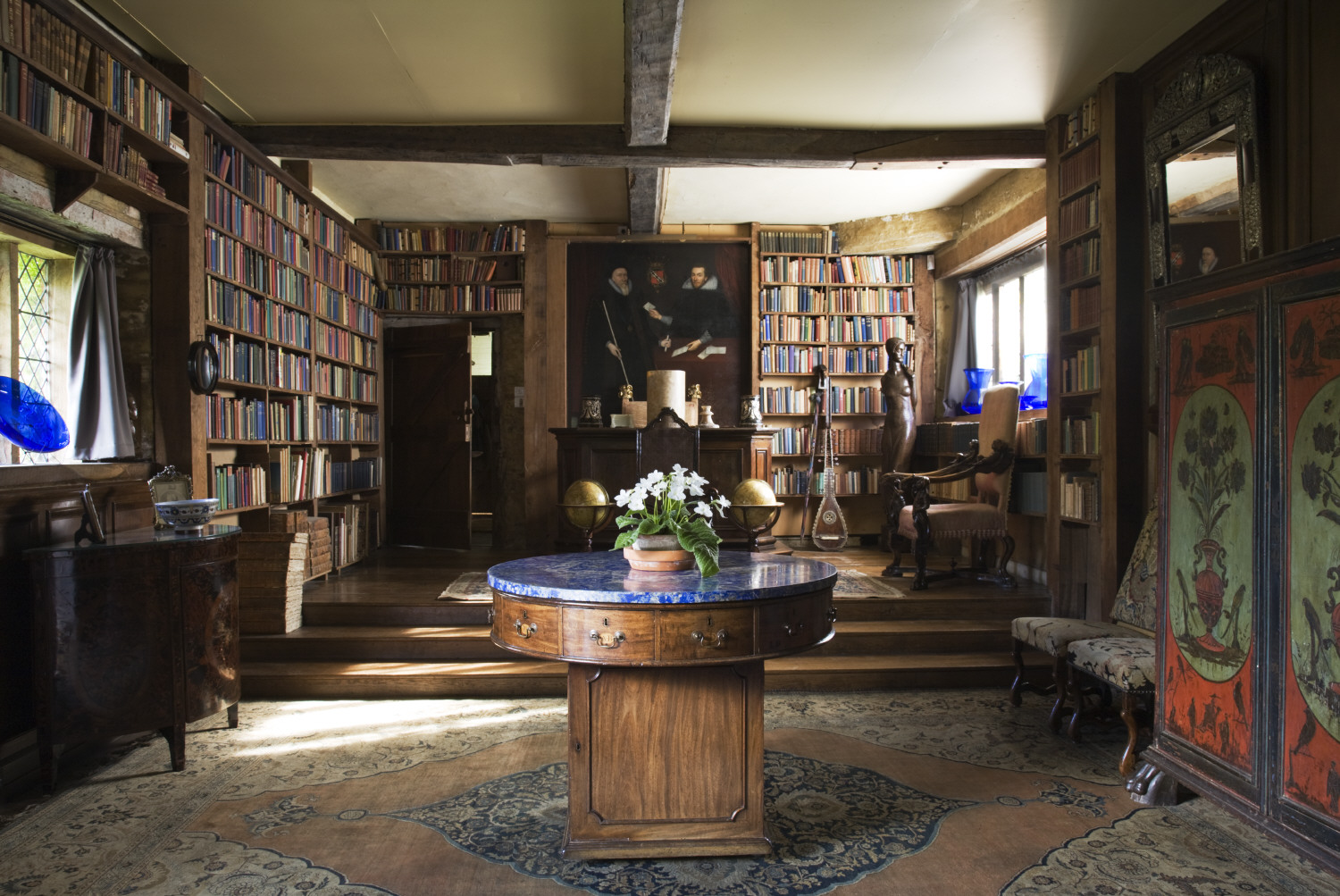 The Long Library at Sissinghurst, home of Vita Sackville-West and her husband Sir Harold Nicolson, near Cranbrook, Kent. This room is the largest in the existing house and was created out of the old stables, and contains the 4,000 books accumulated from 40 years of reviewing. The circular George III mahogany rent table has a lapis lazuli top and is English, 1805.