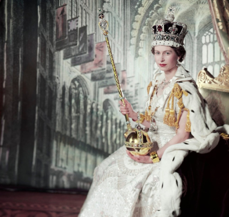 Queen Elizabeth II in coronation outfit sat on throne