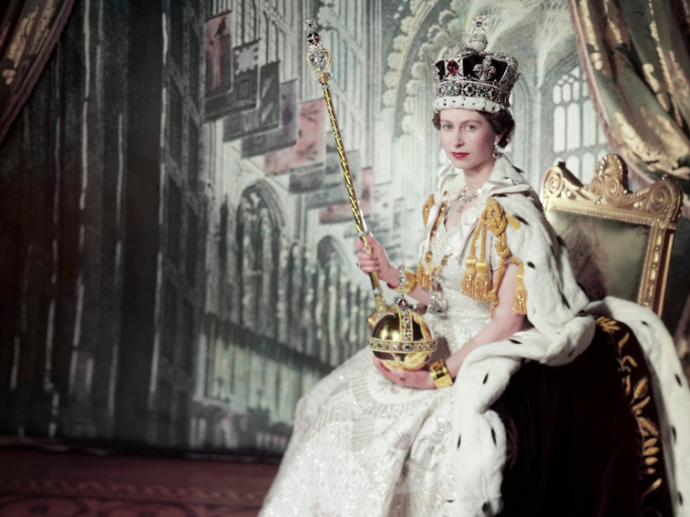 Queen Elizabeth II in coronation outfit sat on throne
